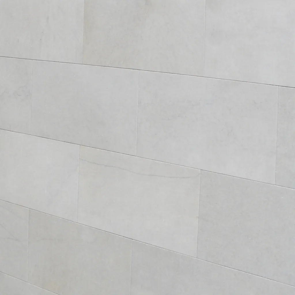 Sandstein-Fassadenplatten in hellem Graubeige im Läuferverband als glatte Wandverkleidung