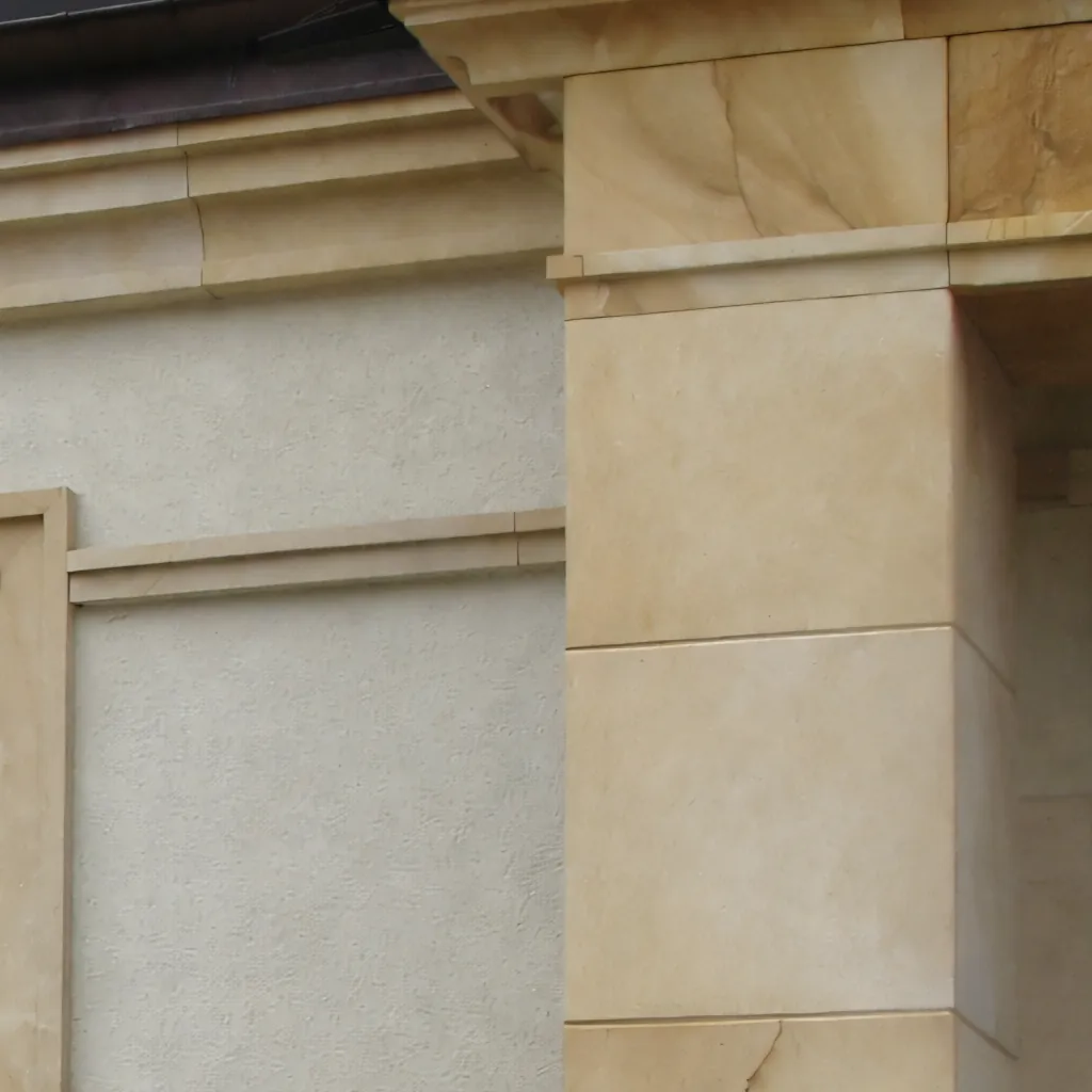 Sandstein-Gesims mit profiliertem Abschluss an Eckpfeiler einer Putzfassade – Detailaufnahme Fassadengliederung