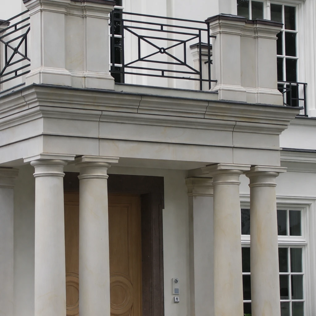 Sandstein-Säulen mit Kapitellen tragen Portikus-Gesims an Villenfassade, darüber Balkon mit Sandstein-Pfeilern und Metallgeländer