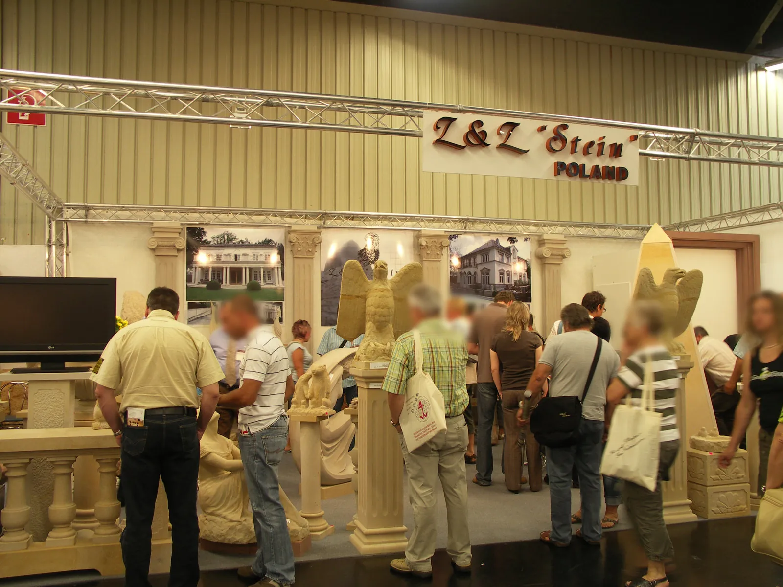 Firma Stein Messestand stone+tec Nürnberg – Sandstein-Skulpturen, Säulen, Balustraden und Ziervögel aus polnischem Sandstein, belebt von Messebesuchern