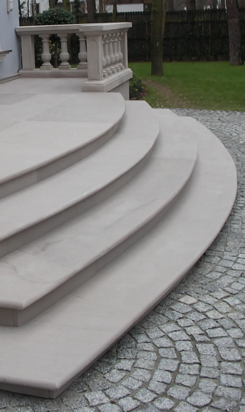Hellweißer Sandstein-Freitreppenanlage mit halbkreisförmig ausladenden Treppenstufen und gedrechselter Sandstein-Balustrade im Hintergrund