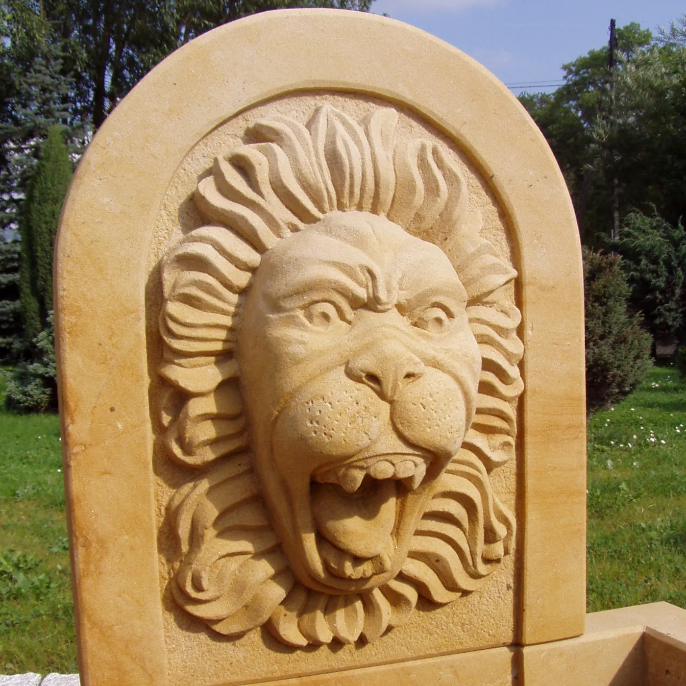 Handgeschnitzter Sandstein-Löwenkopf als Hochrelief in profilierter Bogennische aus gelbem Sandstein – figürliche Steinmetzarbeit