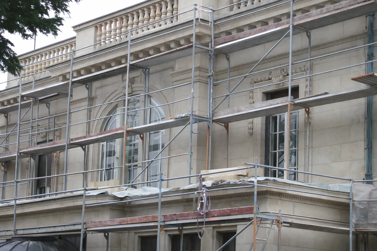Baustelle Wiesbaden – heller niederschlesischer Sandstein-Balustrade mit gedrechselten Balustersäulen auf historischer Repräsentationsfassade mit Gerüst