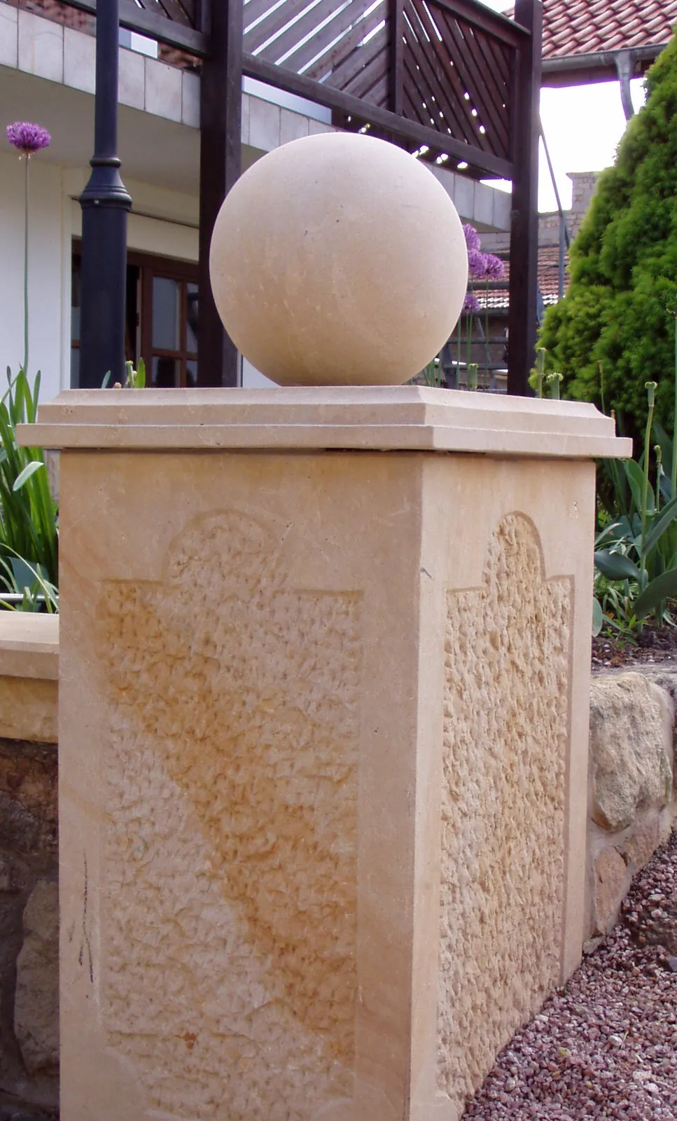 Gelber Sandstein-Pfeiler mit gespitzter Bossenstruktur, glatter Werkstein-Abdeckplatte und gedrechselter Sandsteinkugel als Pfeileraufsatz