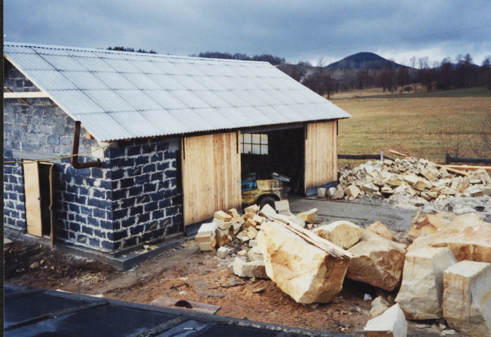rste Steinmetz-Werkstatt von Firma Stein mit polnischem Sandstein-Rohblöcken und Bruchsteinlager auf dem Betriebsgelände – historische Aufnahme