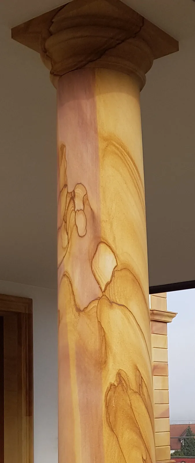 Gelber Sandstein-Säulenschaft mit lebhafter Naturmaserung, toskanischem Werkstein-Kapitell und profilierter Basis – Nahaufnahme Innenbereich