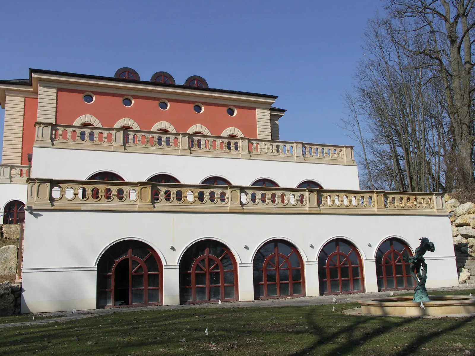 Schlesischer Sandstein – zwei Balustradenetagen mit Okulusornamentfeldern und Bogensimsen an mehrgeschossiger Repräsentationsvilla mit Rundfenstern und Brunnenfigur